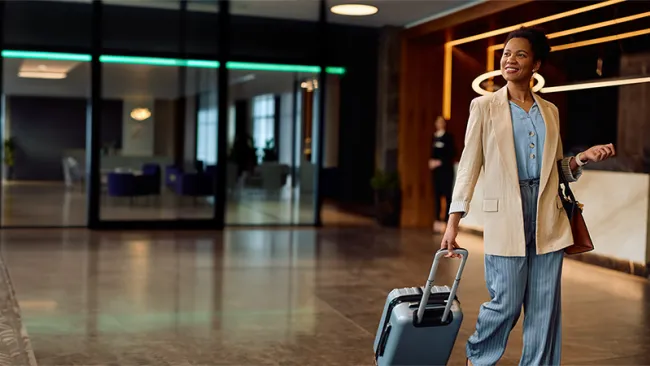 A woman pulling a luggage at a hotel lobby